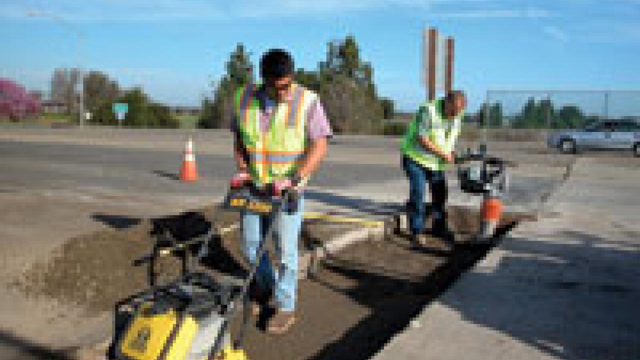 UC employees Enrique Ruiz, left, and Vince Lampman repair a rut in a Hutchison Drive approach.