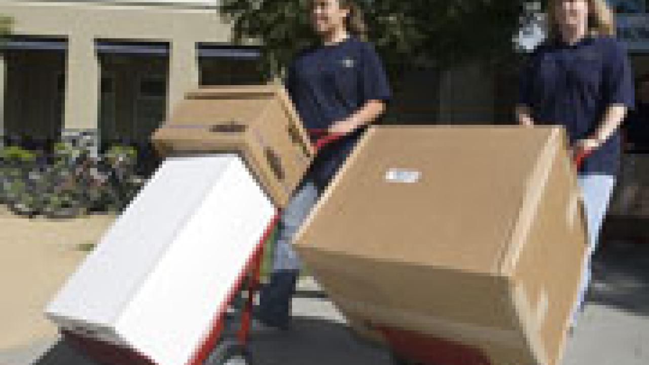 Susan Bounchareune, a senior majoring in microbiology, left, and Laura Chang of Conference Housing take two red dollies for a test run before families and Student Housing employees use hundreds of them to move freshmen into residence halls tomor