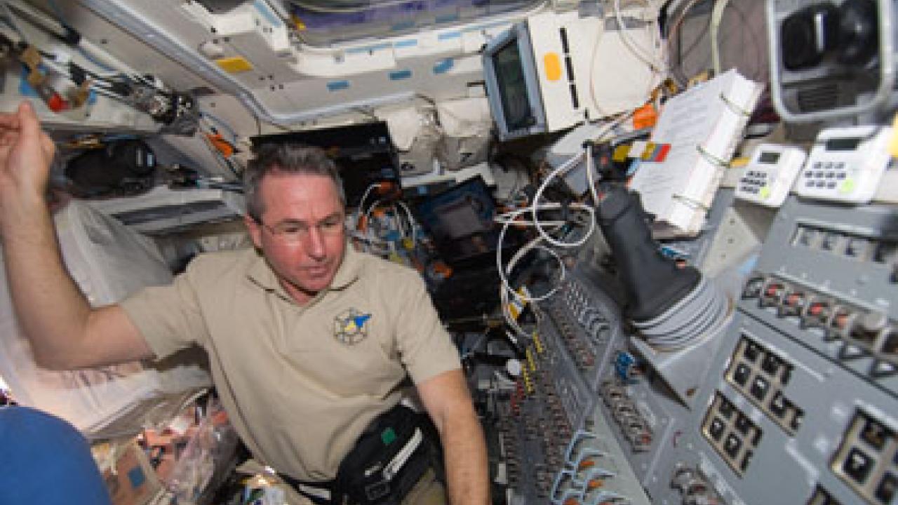Photo from space: Aggienaut Stephen Robinson on the aft flight deck of space shuttle Endeavour during Day 1 activities Feb. 8.