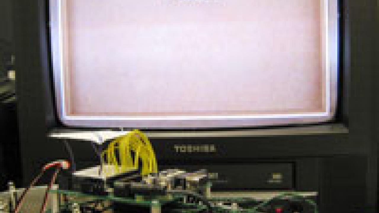 This robot was designed with the same basic senses and motor skills as a rat pup. The television screen shows a videotape of  the robotic rat moving about inside its rectangular arena.