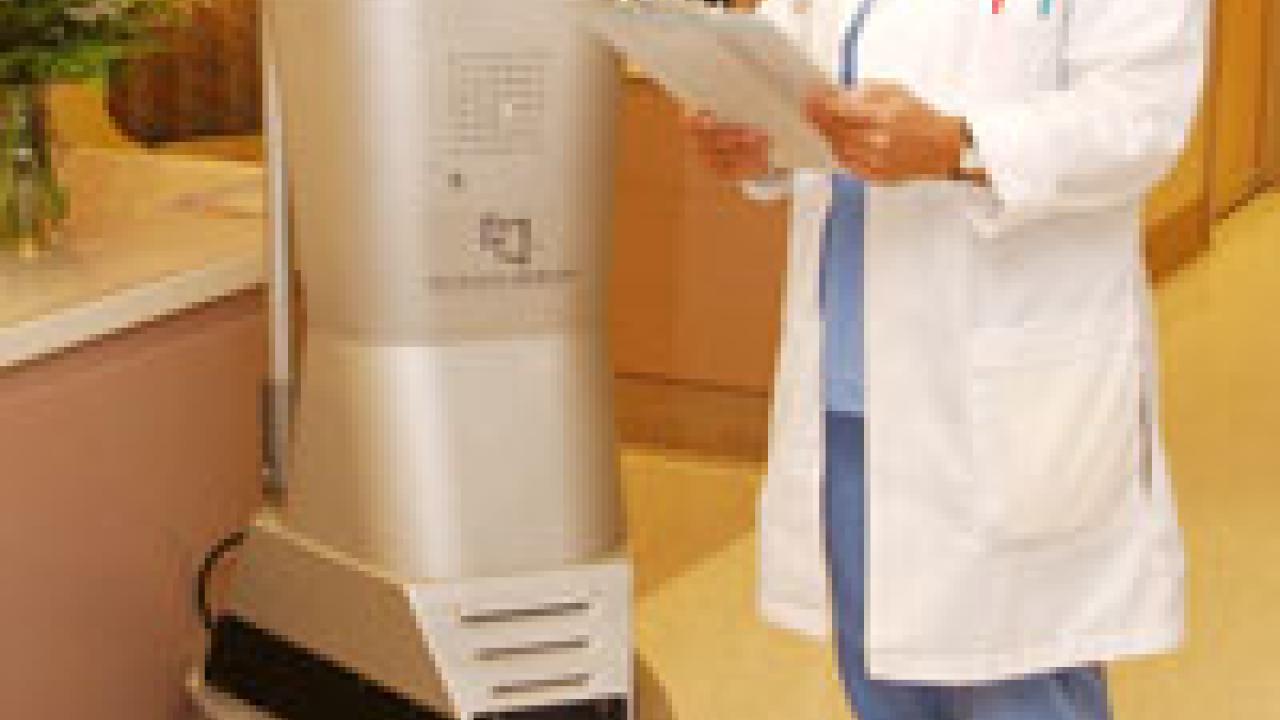 Kitty Gebhart works with "Rudy," the medical center's new rounding robot.