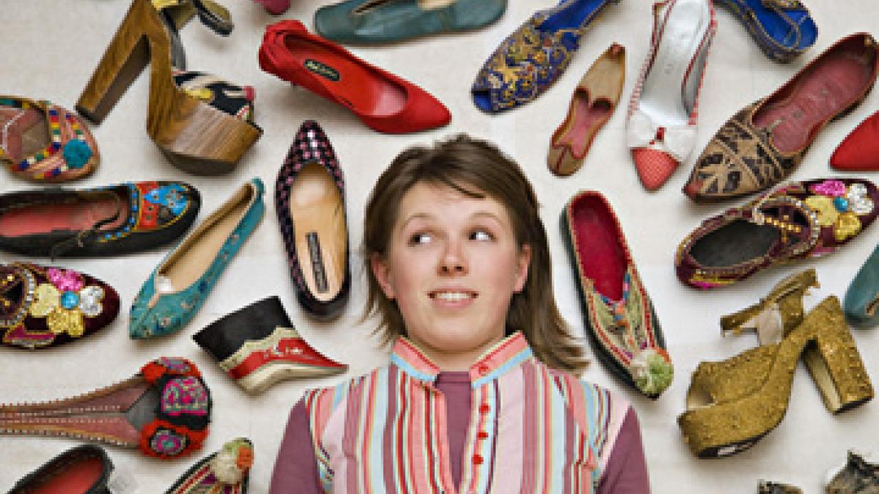 Student Nora Cary is pictured amid a selection of shoes from the exhibition "Stepping Out -- Footwear from Around the World."