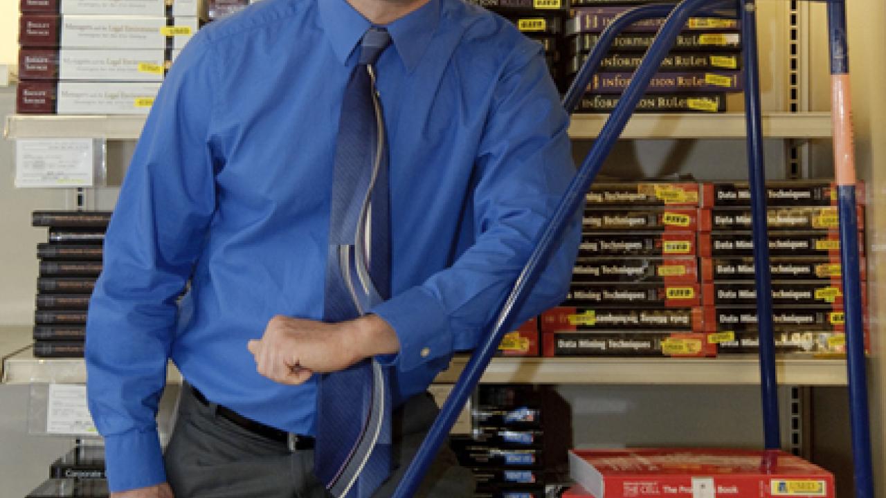 Photo: Jason Lorgan, associate director of the UC Davis Bookstore, and a sampling of the bookstore's rental textbooks