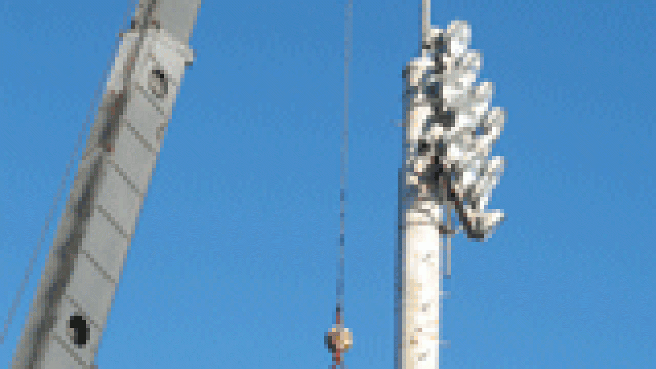 A worker for STC Netcom helps with the rigging after a crane erected the Davis campus&rsquo;s first cell tower on Dec. 20. The cell antennae, which sit atop the 80-foot steel tower at Howard Field near the north entry garage, have since been sheathe