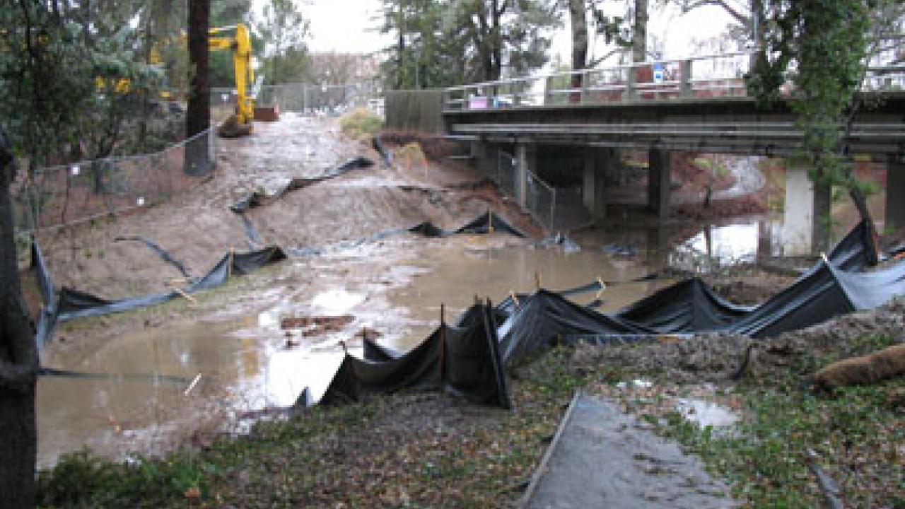 A temporary culvert and earthen dam are submerged in the arboretum waterway the afternoon of Jan. 4, just west of the California Avenue bridge. The culvert and dam had been installed in preparation for a project that calls for placing utility pi