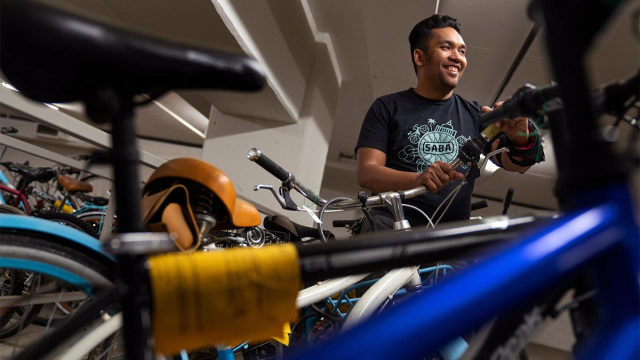 Aaron Curtin stands with bicycles.