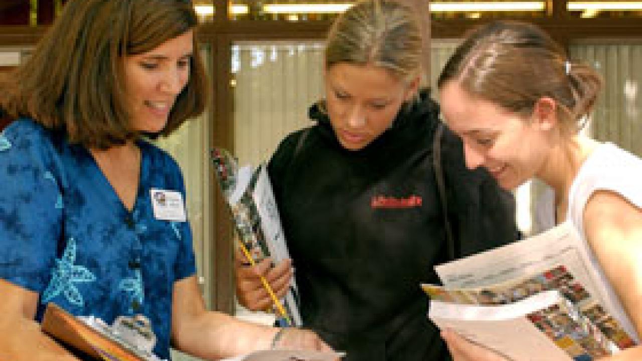 Student advising co-director Tammy Hoyer talks with newly-admitted incoming students Kerry Klotzbach and Anna Bokides.