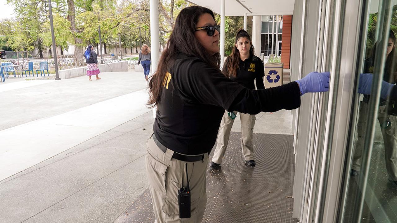 Student employees of the police department check to see if doors are locked.