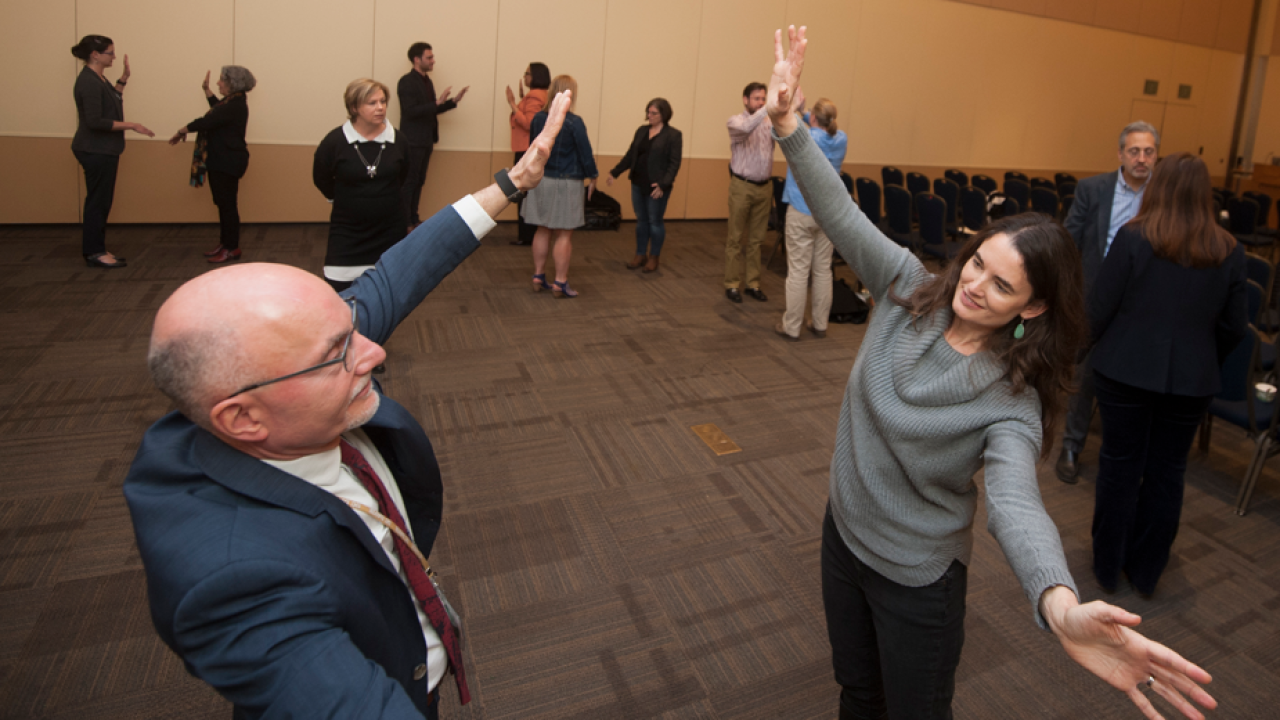 Two people standing, "mirroring" each others movements.