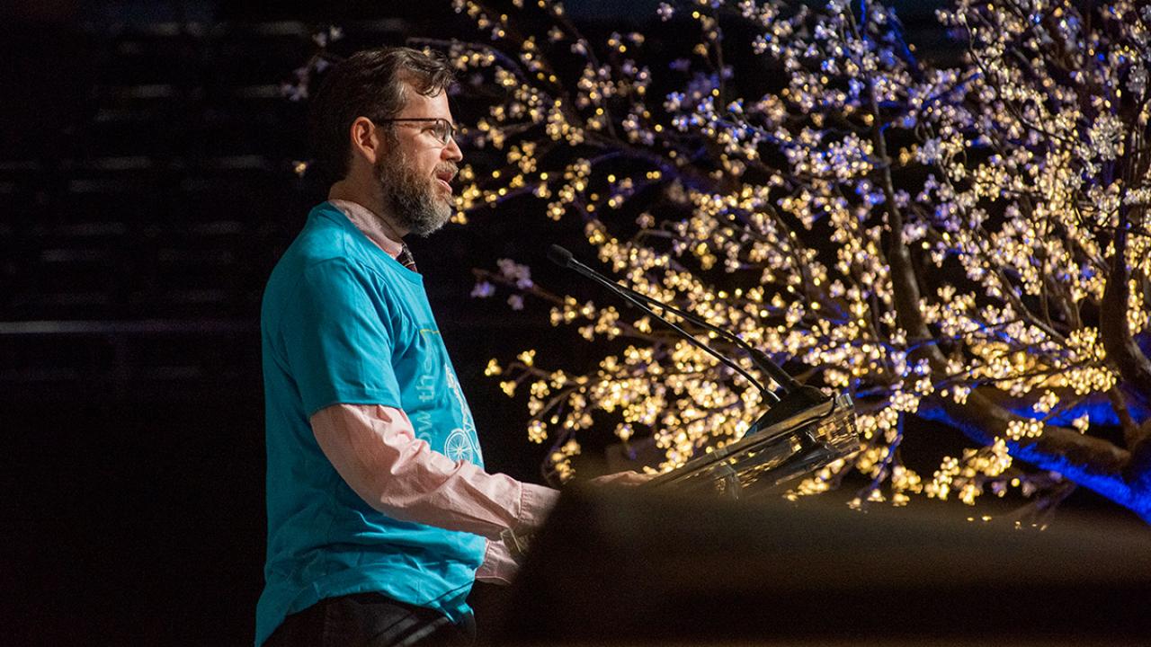 Andy Jones reads his poem on stage.