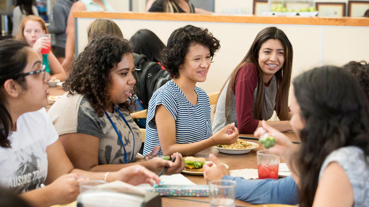 Female students talk over lunch in a dining commons