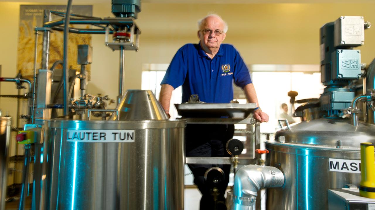 Charlie Bamforth stands amid brewery tanks.