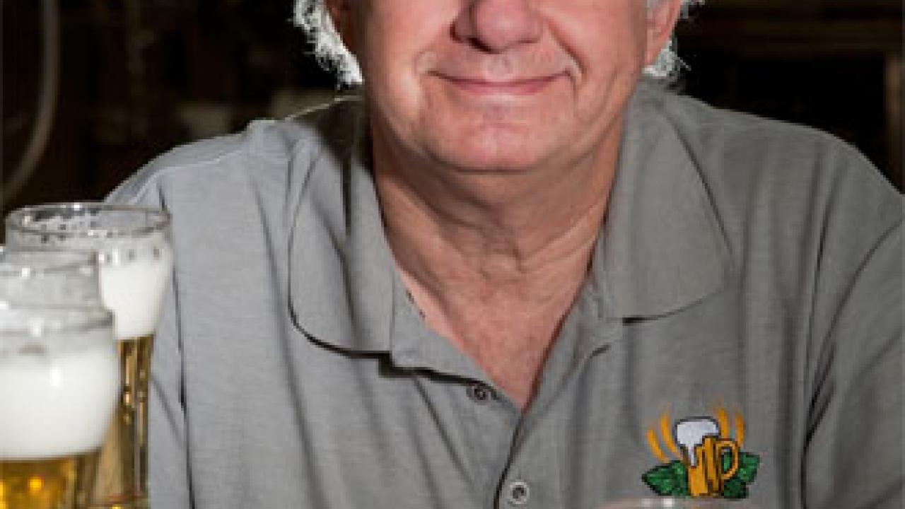 Charlie Bamforth sits behind a dozen glasses of foam-topped beer.