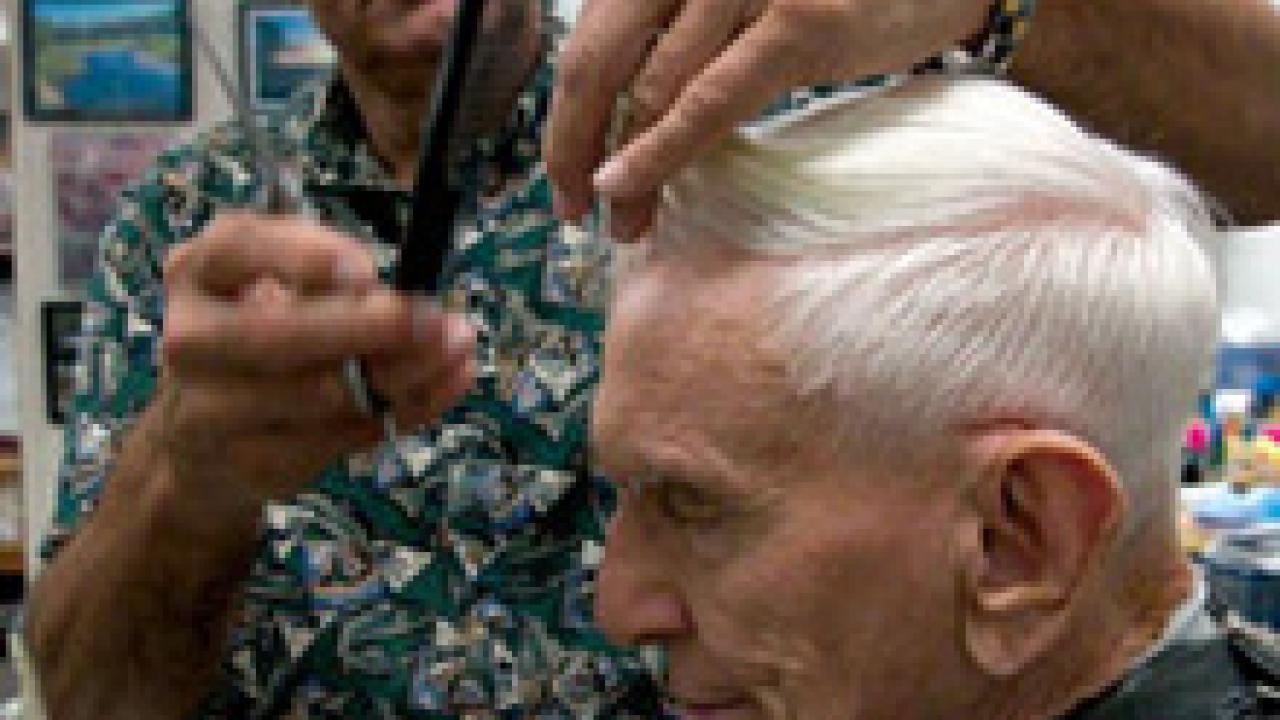 Longtime campus barber John Salido trims the hair of a frequent customer, professor emeritus Emanuel Epstein.