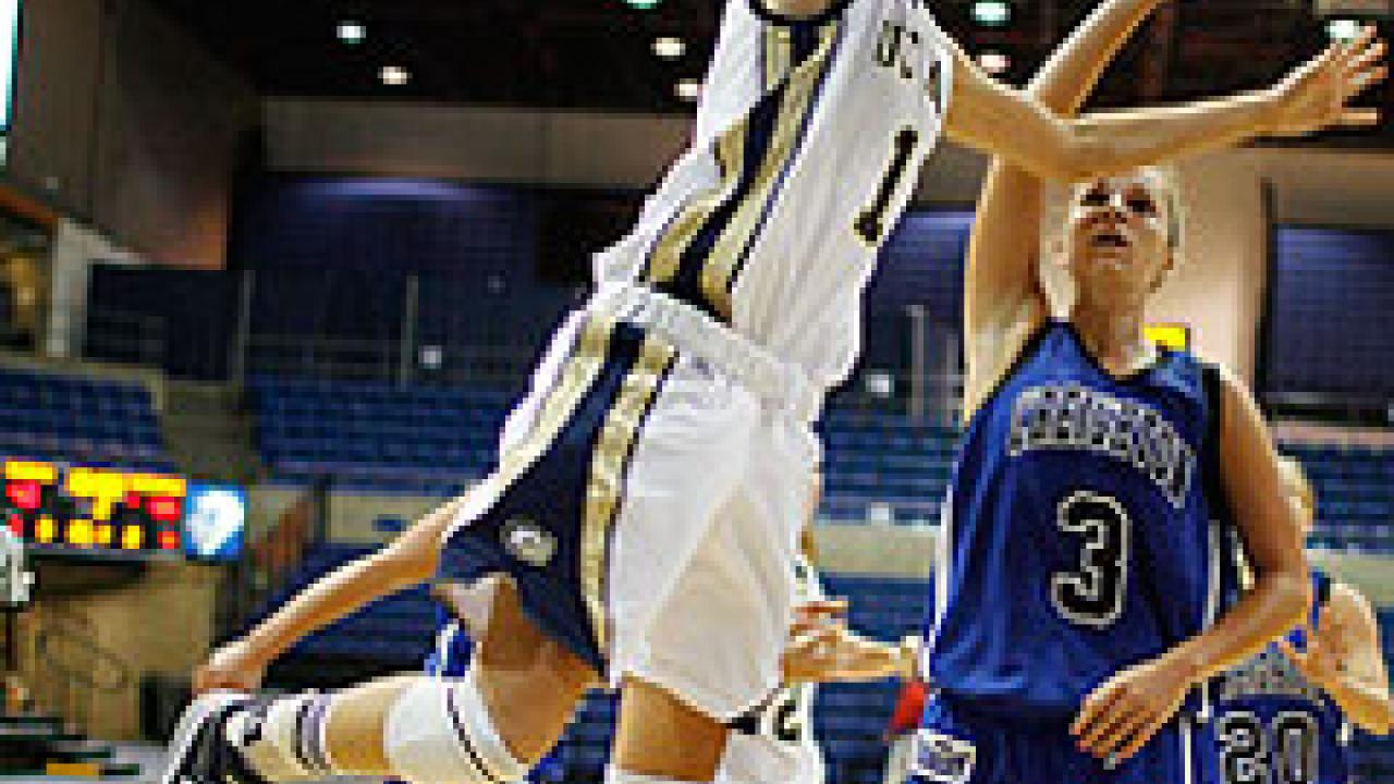 Photo: women playing basketball, with one going for a layup