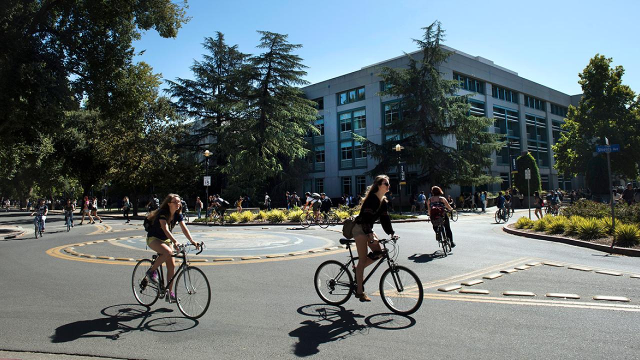 Students bicycle near Shields Library.