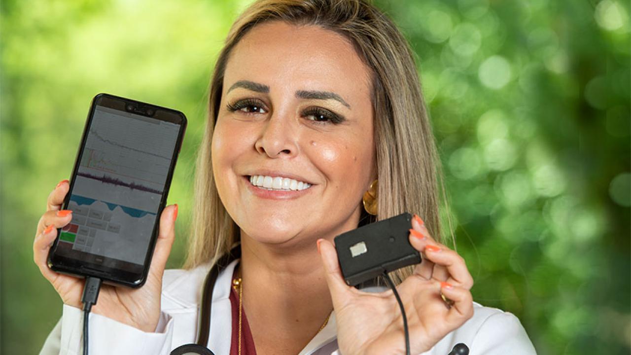A woman holds up a device