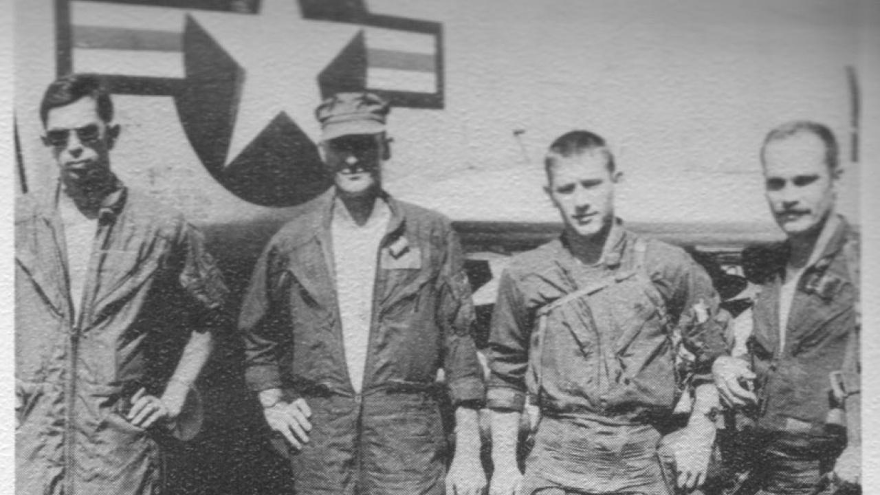 Black-and-white image of four GIs on airfield, during Vietnam War
