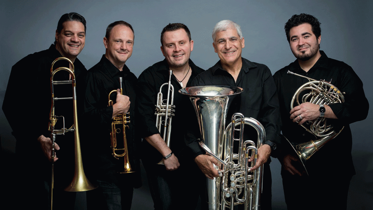 Five men, each holding a brass instrument