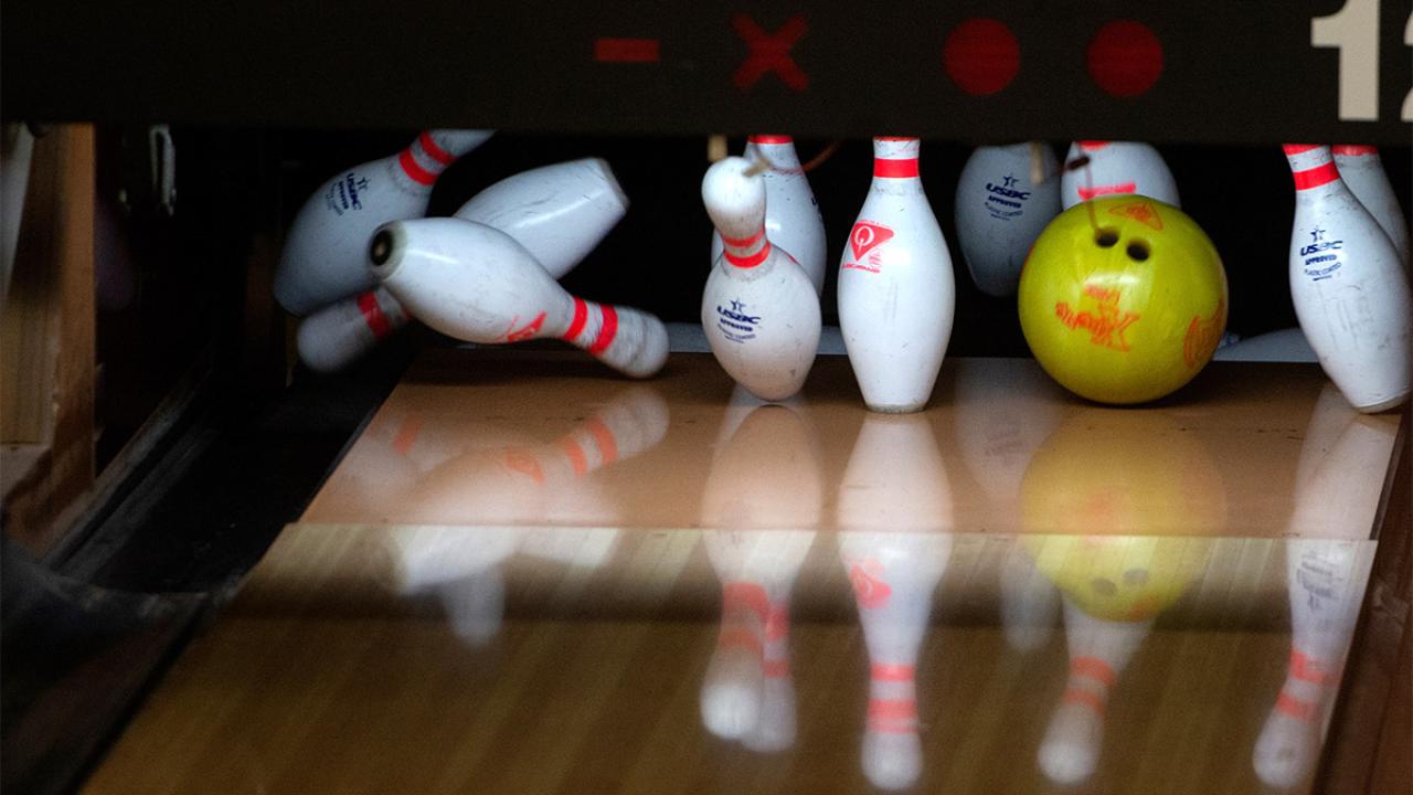 Bowling pins being hit by a bowling ball.