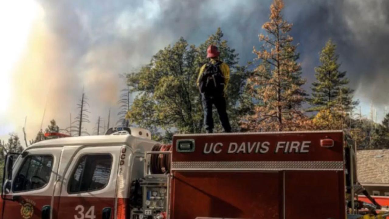 Firefighter stands on top of fire truck