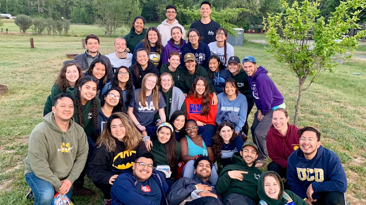 Group of students pose for photo in field.