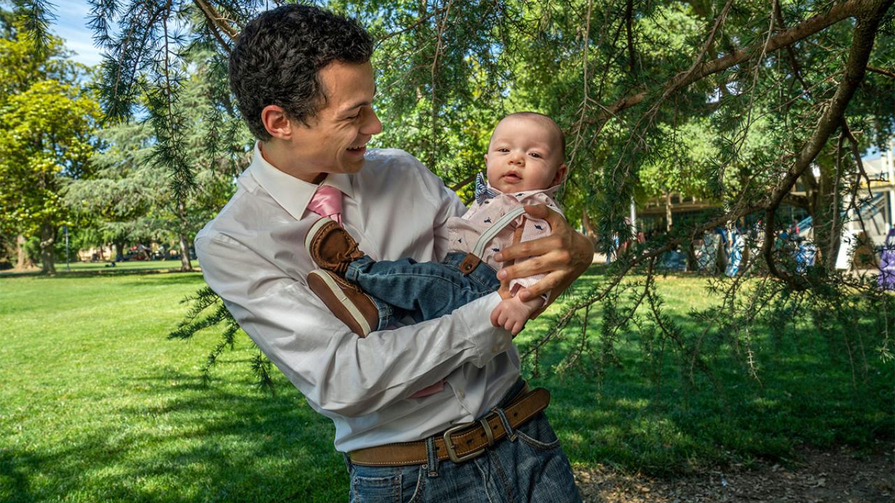 A student holds his baby.
