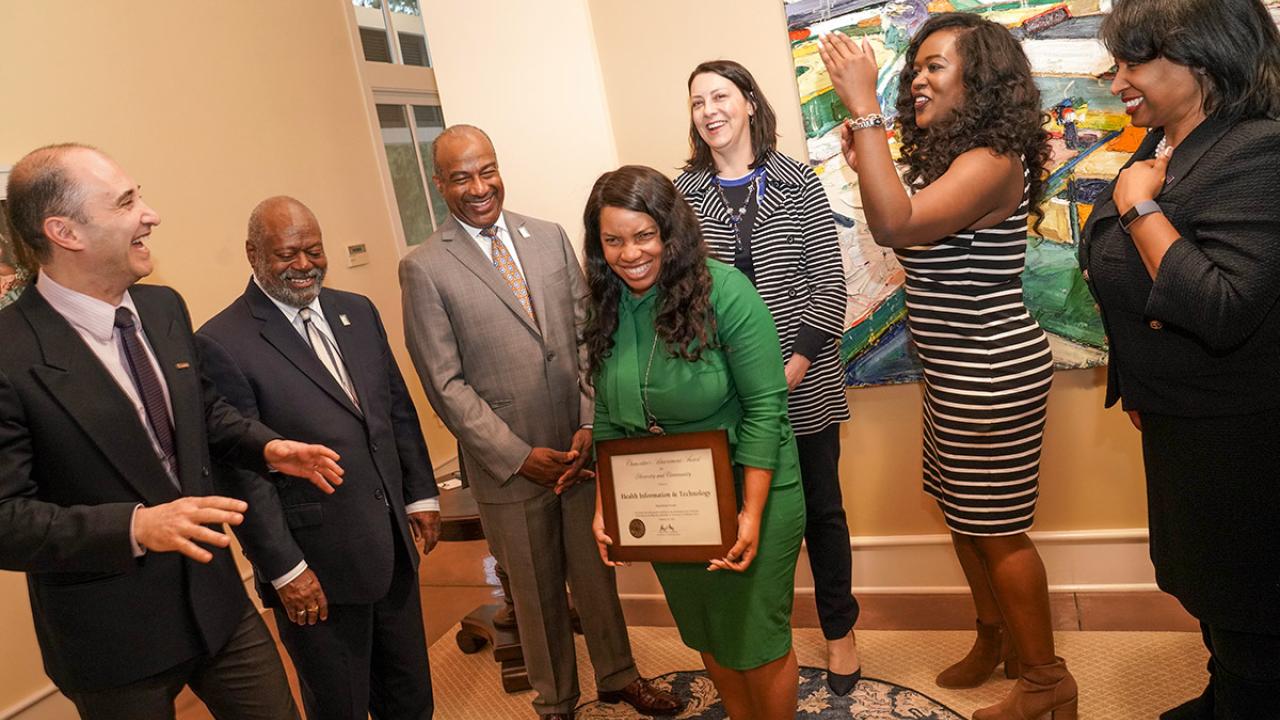 Group of people laughing with plaque.