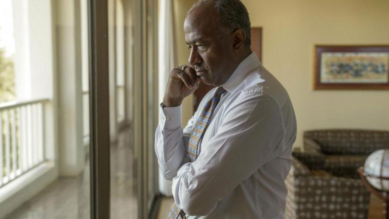 Chancellor Gary S. May has a serious expression as he looks out a window.