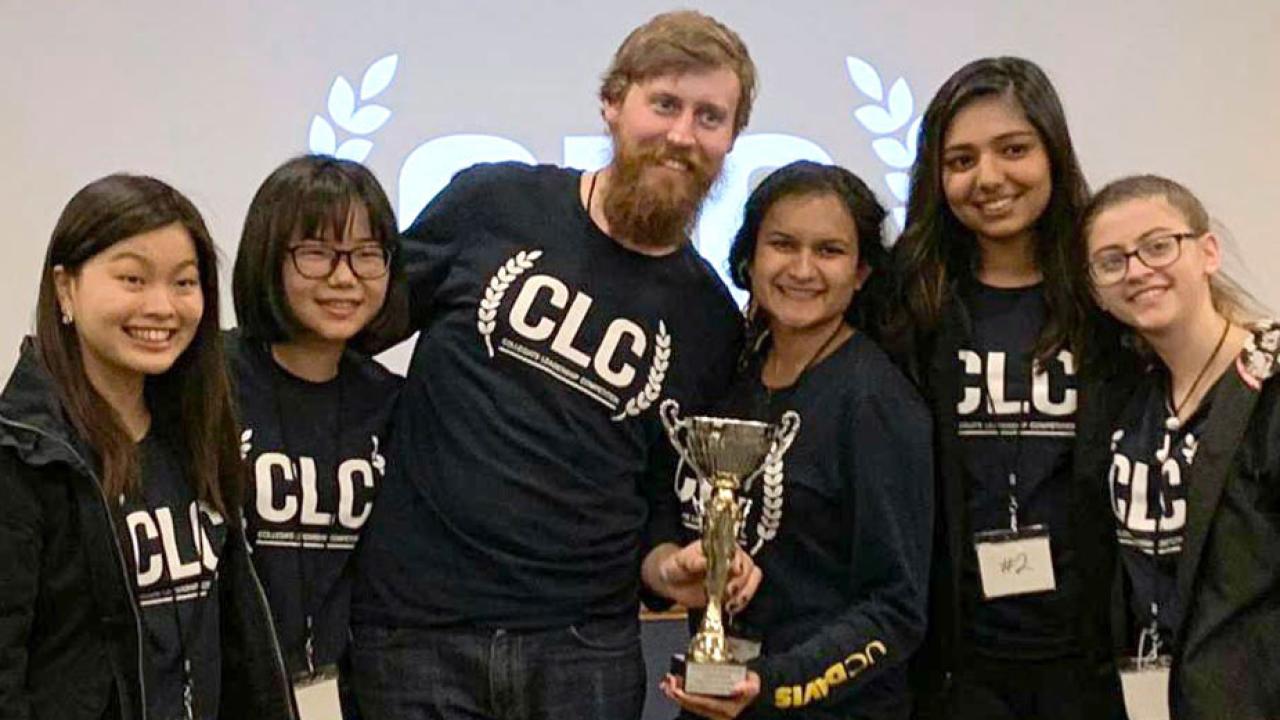 Six students pose with trophy.
