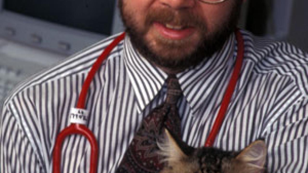 Photo: Man with stethoscope cuddling cat