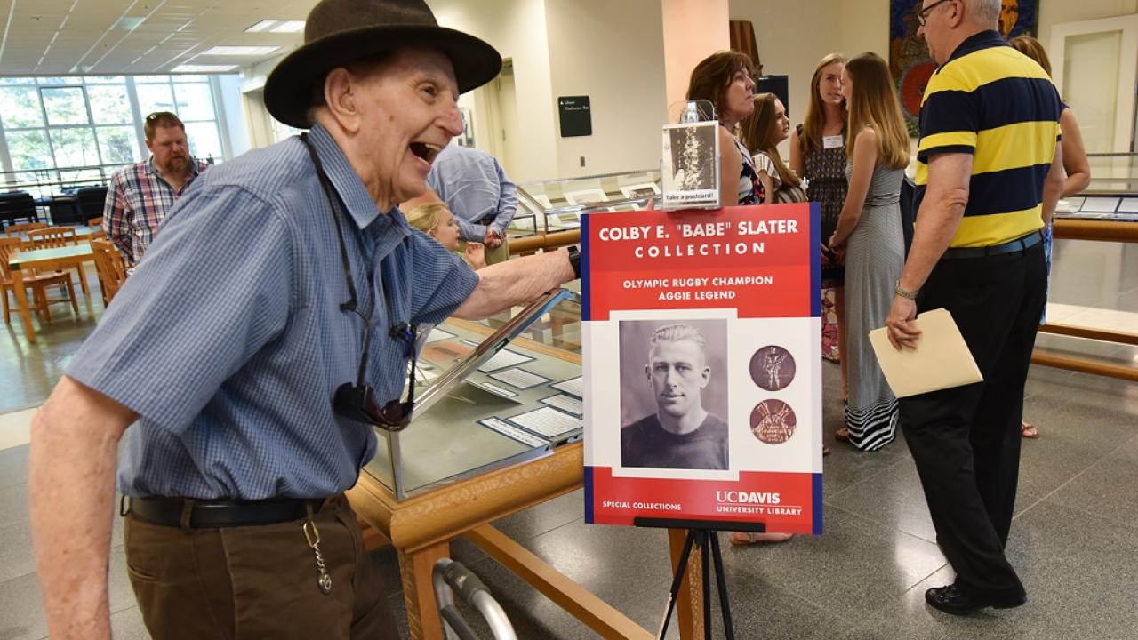 Edward Slater stands next to a poster of Colby "Babe" Slater.