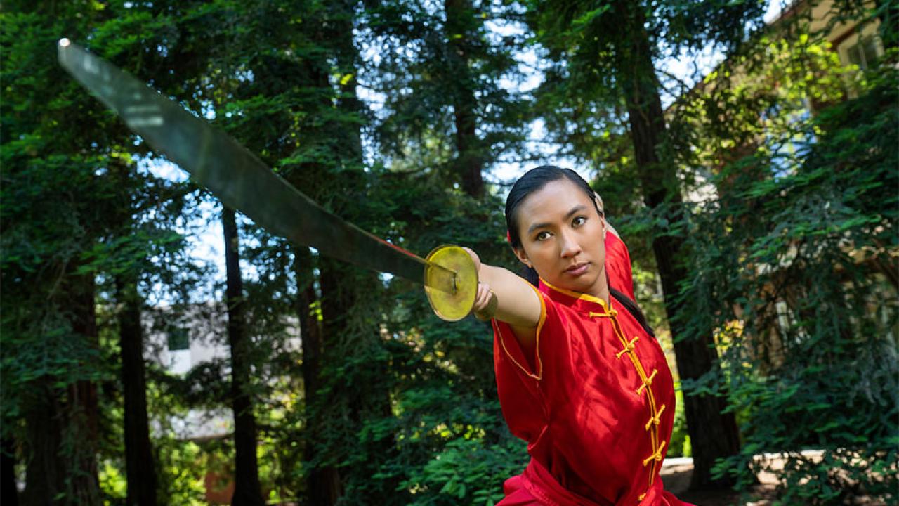 Woman executes sword movement in wushu martial arts