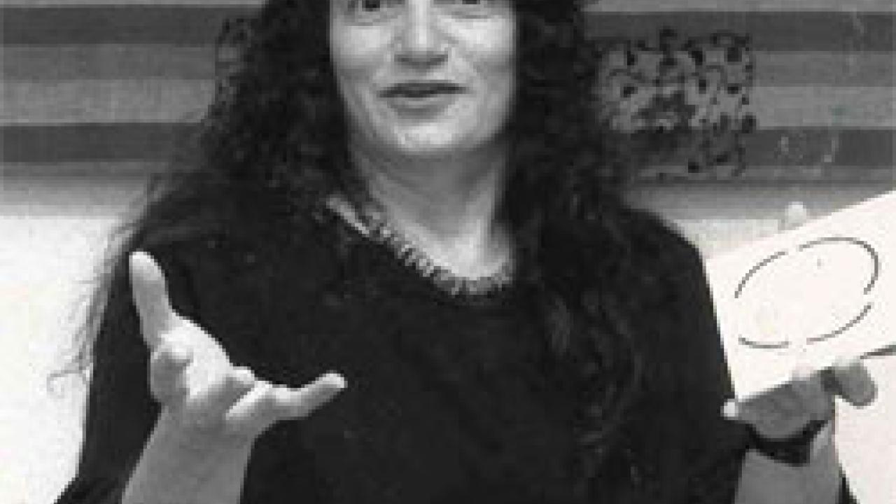 Photo: woman gesturing and holding a card