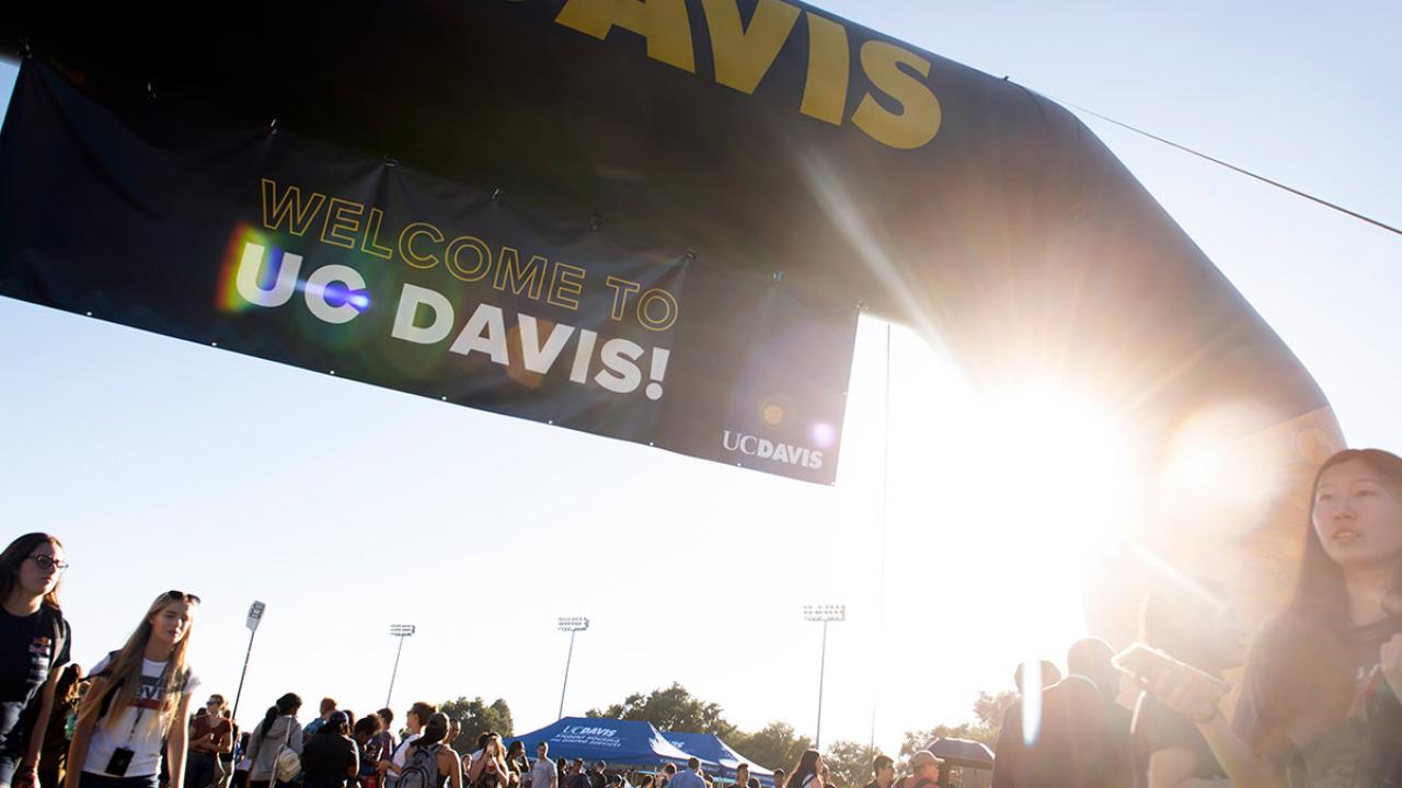 An arch with a sign that reads "welcome to UC Davis."