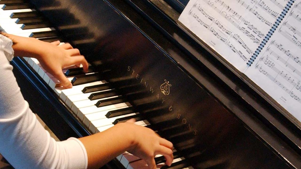 Arms of a young woman playing the piano