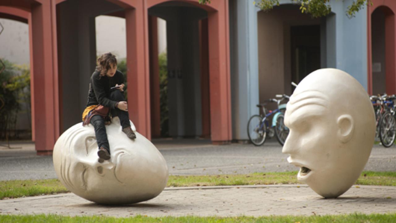 Photo: Unidentified person sits on one of the Eggheads in the "Yin & Yang" installation.