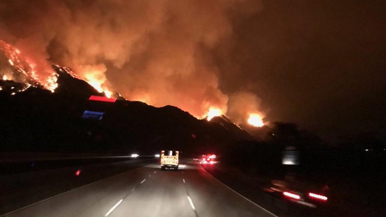 Fire trucks drive toward the Thomas Fire.