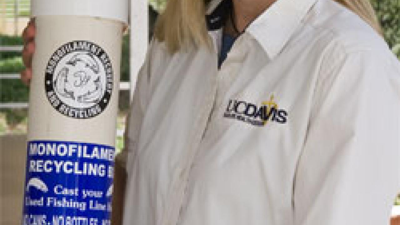 Kirsten Gilardi displays one of the recycling bins that are being installed at piers from Santa Cruz to the Mexican border, to give anglers a place to discard unwanted hooks and line.