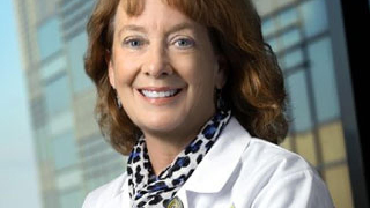 Smiling woman in a doctor's white coat and a leopard skin scarf