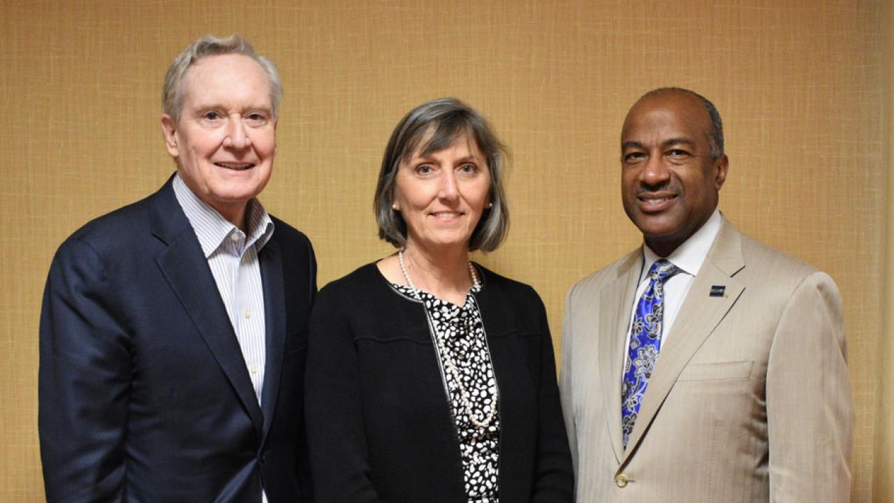 Three people, posing for photo.
