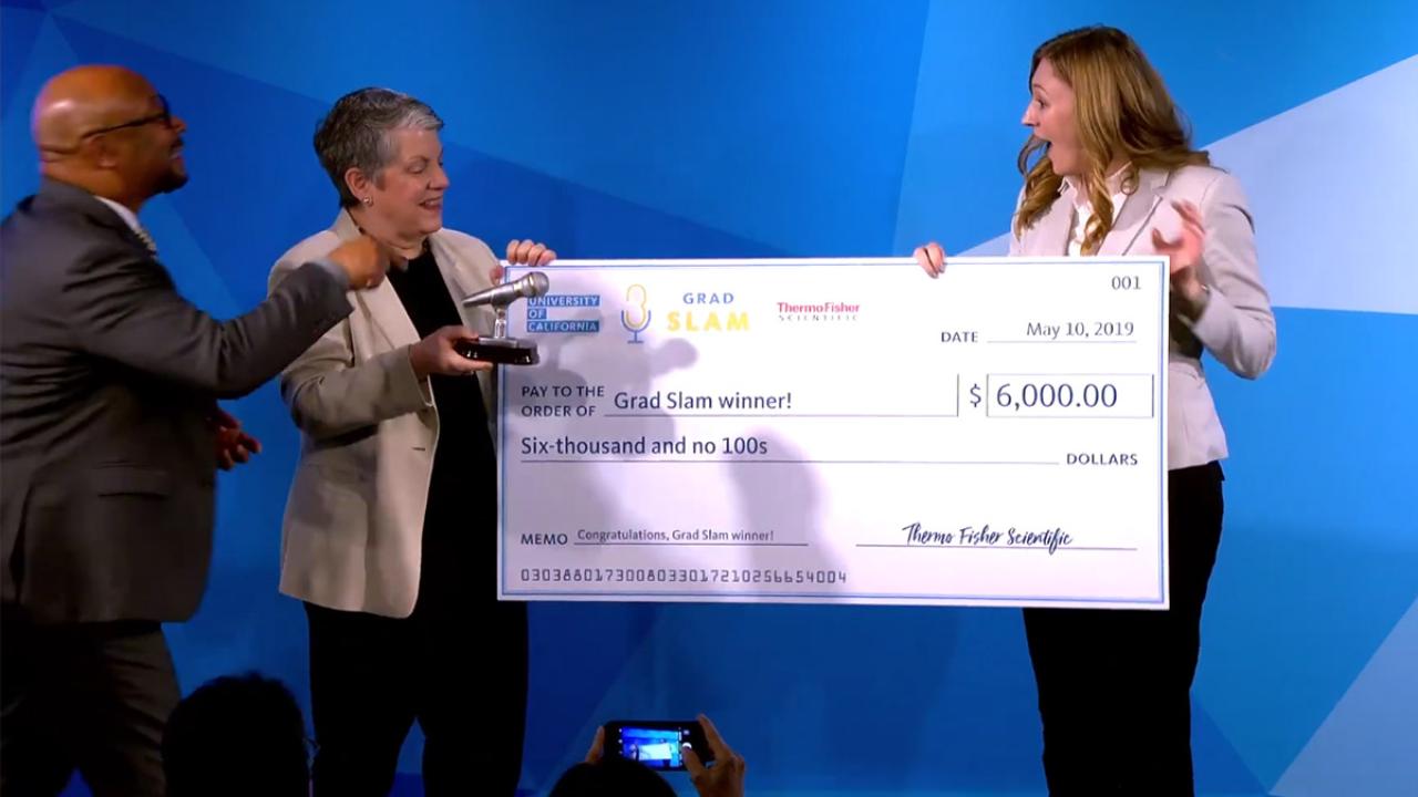 Katie Murphy receives a trophy and giant check.