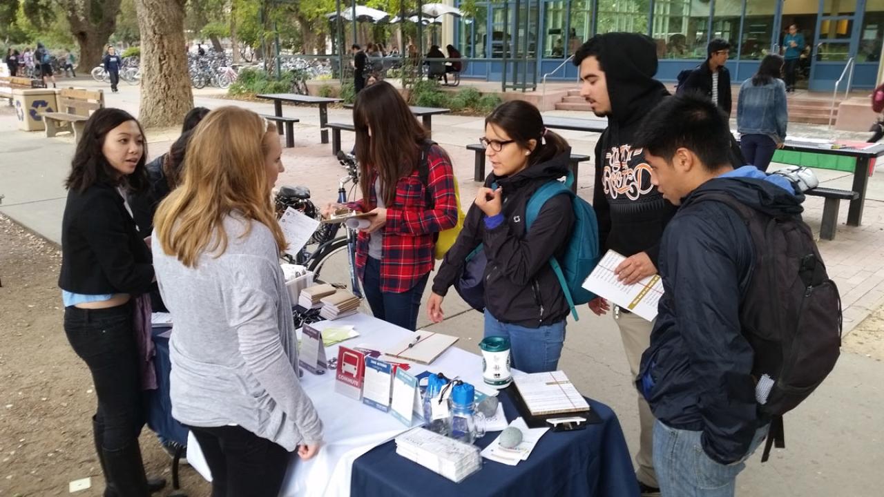 Students gather around a table.