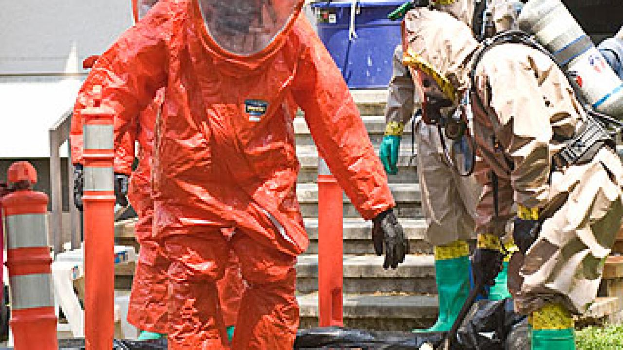 UC Davis firefighters wearing orange hazmat suits