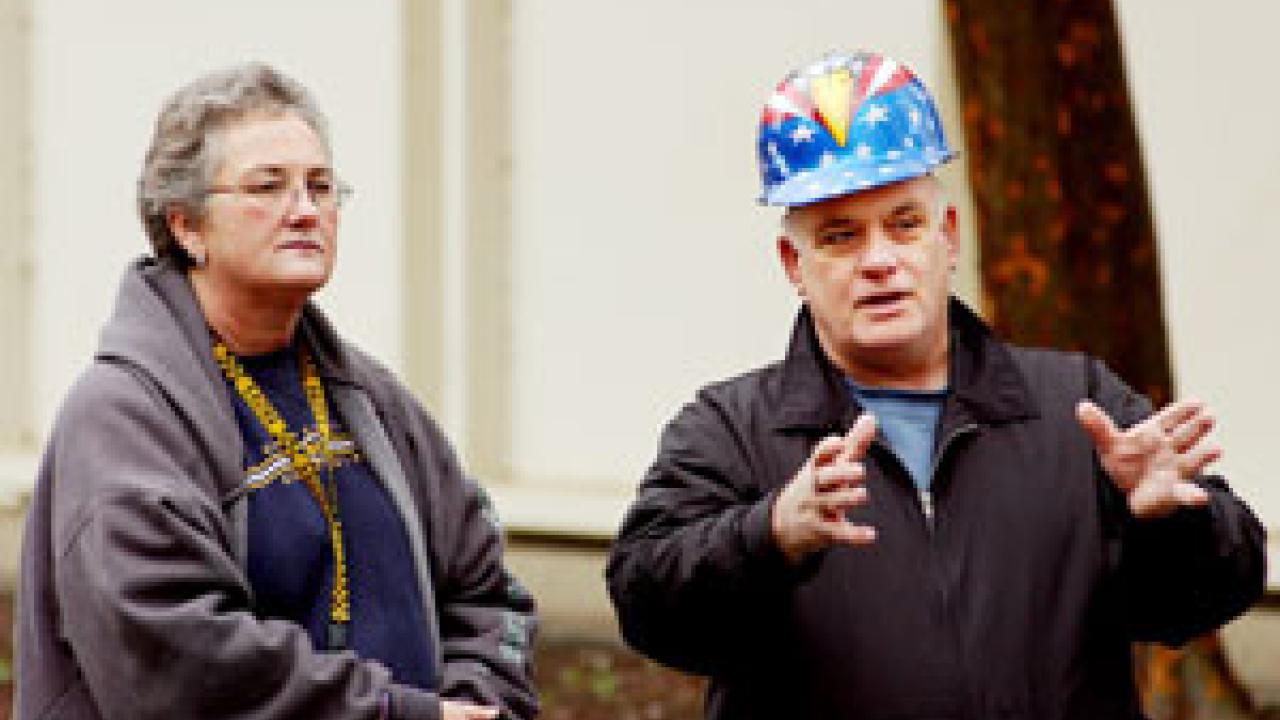 As the Hog Barn rolls by Saturday, associate construction administrator Sam Bianco, below, talks with Toni Nicholson of Staff Development and Professional Services, who will be a tenant in the barn after its renovation. 