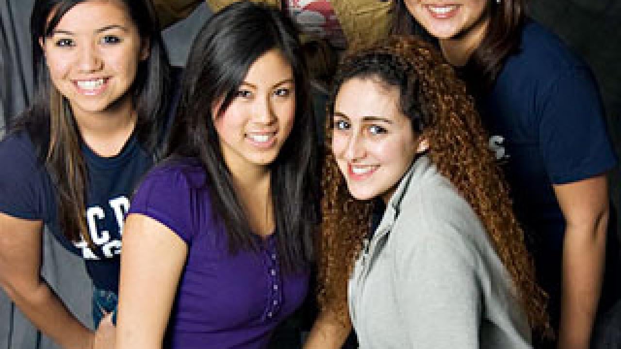 Photo: four women grouped with a guy holding a videocam