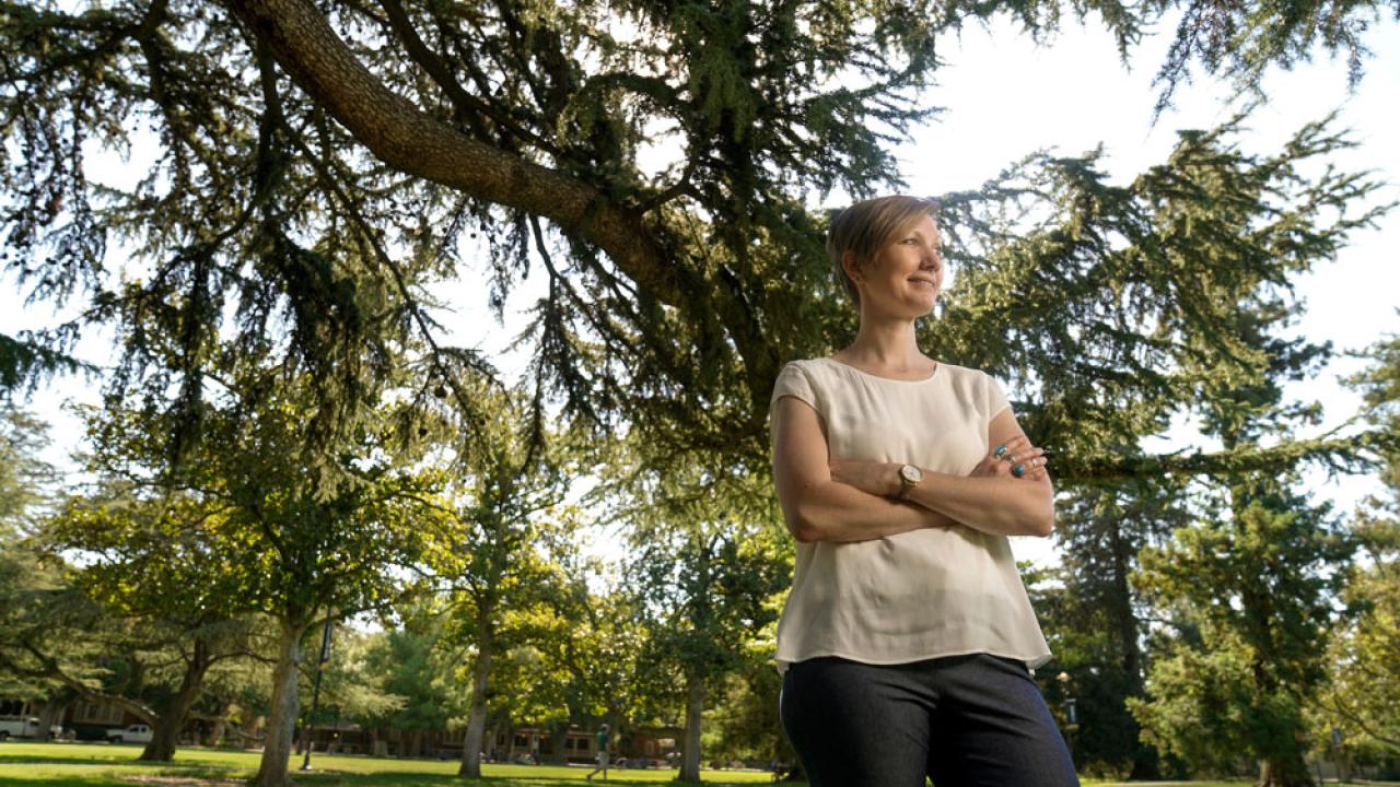 Ingrid Bergman stands amid trees on the Quad.