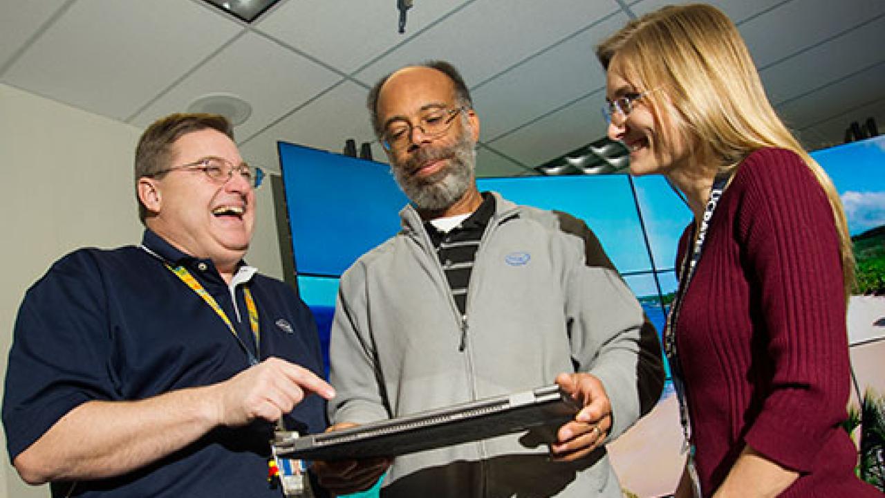 Aggie alumni share a look at a computer screen.