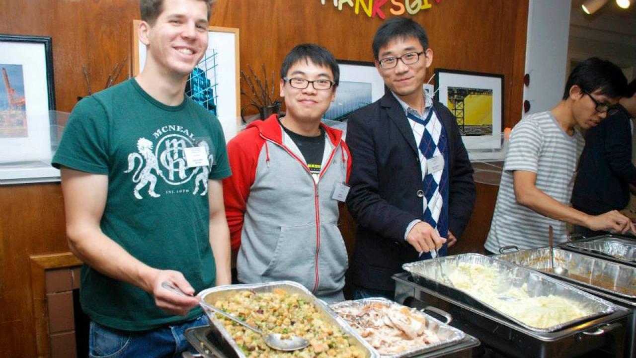 Volunteers serve food during the International House's annual Thanksgiving dinner.