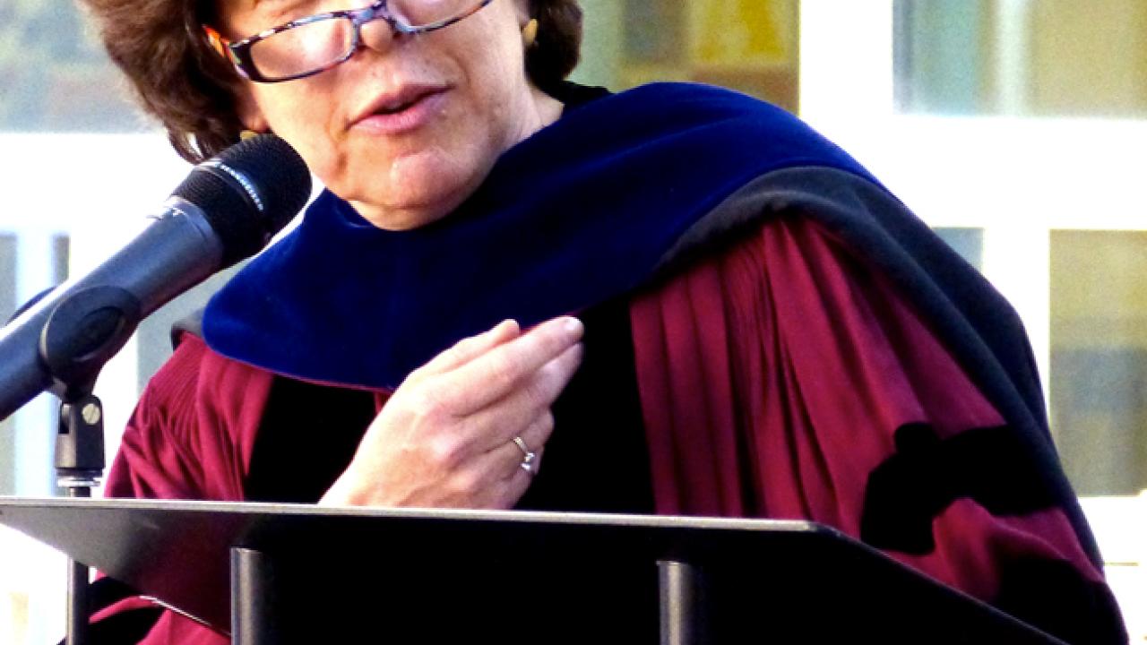 Photo: Professor Naomi Janowitz in academic regalia, behind podium